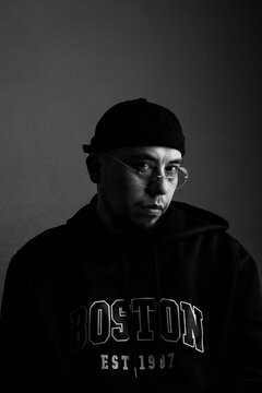 black and white portrait of a hispanic man with a hat and glasses