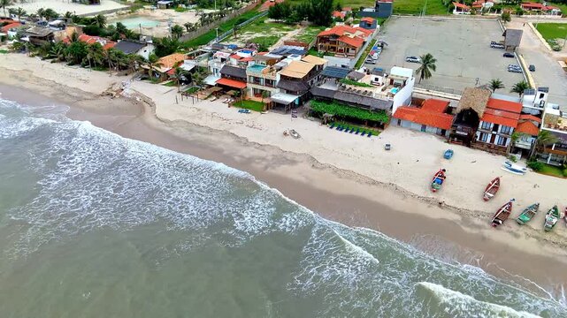 Drone Shot of Waterfront Pousadas and Colorful Boats on Sandy Beach in Ceara Brazil