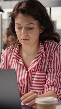 Vertical Video Woman staff working on laptop in smart office corporation at desk, providing business management for new strategy and project development. Worker ensuring productivity startup culture.
