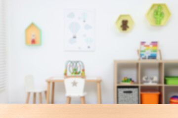 Empty wooden table in playroom, selective focus. Space for design