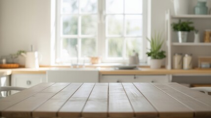 Fototapeta premium A light wooden dining table stands in front of a blurred modern kitchen.