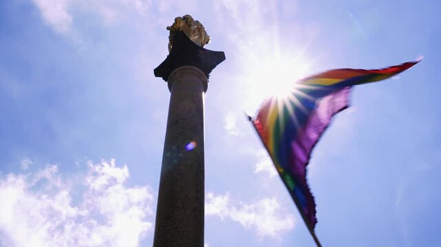 Regenbogenflagge vor der Mariens&auml;ule in M&uuml;nchen mit Sonnenlicht beim Christopher Street Day