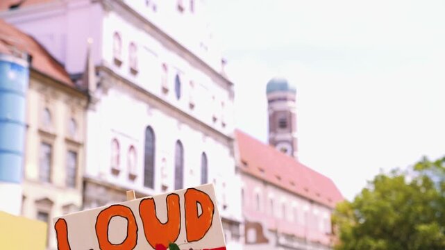 Plakat Loud and Proud mit Regenbogen beim Christopher Street Day in M&uuml;nchen vor Frauenkirche