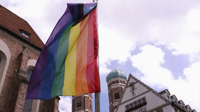 Regenbogenflagge in Zeitlupe mit Frauenkirche im Hintergrund beim Christopher Street Day in M&uuml;nchen