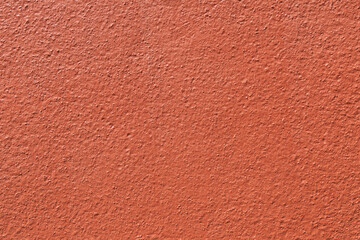 Fototapeta premium Orange stucco wall texture background. Close-up of bumpy painted terracotta plaster surface