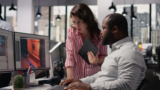 Game developers working on futuristic video game on computer, diverse team uses programming tools and software to design virtual world with spaceships and stations. Assets for gaming industry.