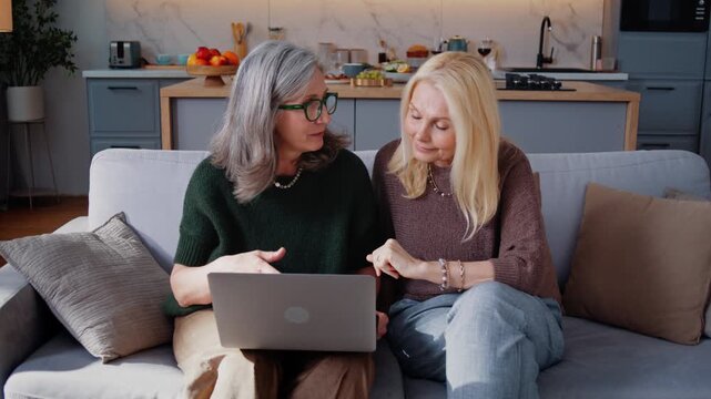 Senior women discuss internet content together while seated