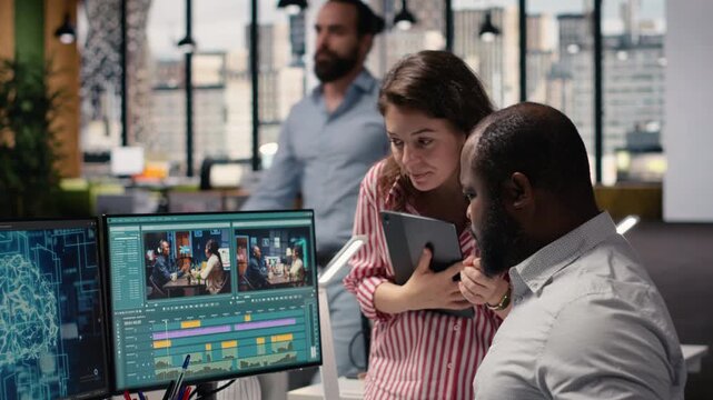 Creative team editing film footage with artificial intelligence software, transforming raw recorded clips into montage. Dual monitors show optimization tools powered by machine learning.