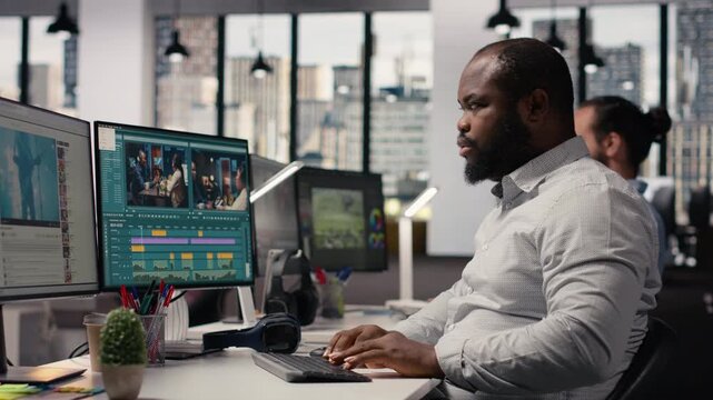 African american filmmaker editing video footage for content production, raw recorded clips on computer software. Videographer cutting frames and adding visual effects, film agency.
