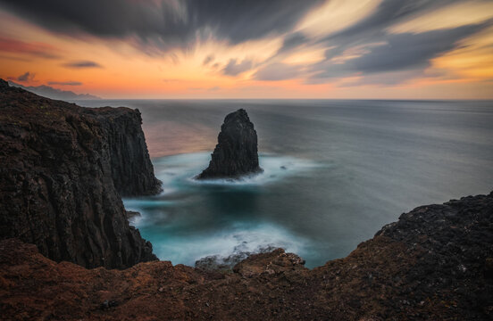 Outcropping rock known as Roque partido or Farallon de Tabata in Gran Canaria island, Canary Islands, Spain. Long exposure picture at sunset. March 2026