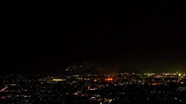 市街地の夜景と遠景に打ち上がる江津湖花火大会
（コピースペース有り）
「水の都」熊本市の美しい夜景を背景に、遠く江津湖から打ち上がる花火を広角で捉えた定点ショットです。画面上部には広大な夜空の余白があるため、番組タイトル、広告コピー、ロゴなどの配置に最適な『背景素材』として設計されています。
Night View and Fireworks Display in the Distant Lands