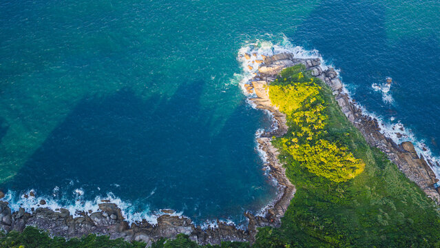 Top down aerial view of Ponta do Araca peninsula with turquoise ocean and rocky coastline in Porto Belo Brazil.
