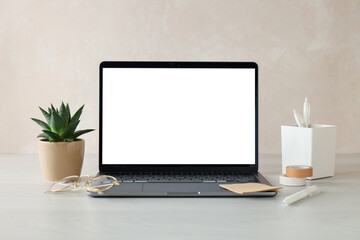 Fototapeta premium Stylish workplace. Laptop with blank screen, houseplant and decor on white wooden table