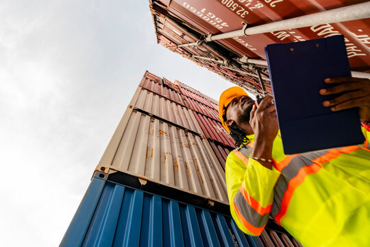Technical specialist evaluating cargo container status and global shipping protocols. Professional site inspector supervising maritime logistics and freight infrastructure at a shipyard depot.