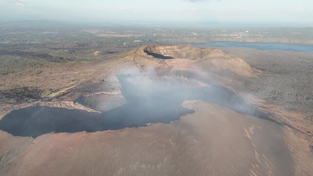Deep wide volcano crater with smoke aerial drone view on Nicaragua landscape background