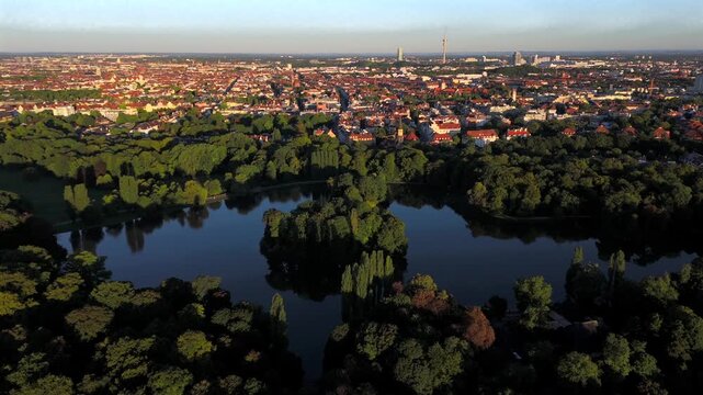 Aerial panorama of Munichs English Garden with Kleinhesseloher See and islands. Popular holiday attraction in Germany. Green parkland, water, forest and heritage site in Bavaria