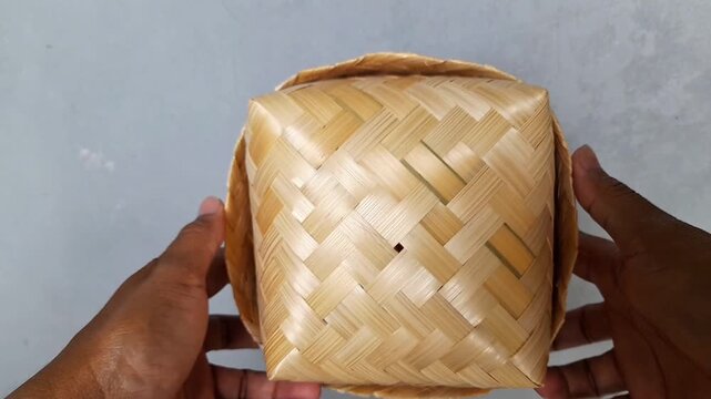 Indonesian traditional besek or a food container made of woven bamboo. Traditional Javanese and Indonesian boxes are called besek