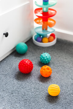colorful toddler sensory balls and slide toys in child bedroom for early learning