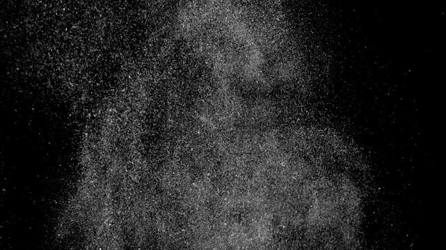 White dust particles and fine flour floating on black background
