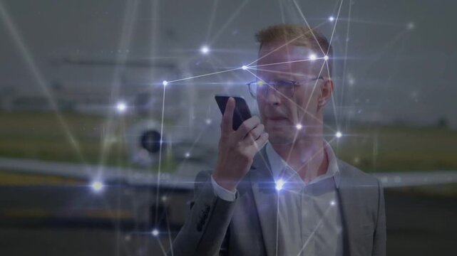 Exec examining phone on apron speaking into device to plan departure as network pulsing outward