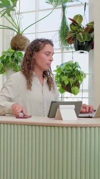 Vertical video: Checking phone person typing on laptop and writing in notebook at counter for work