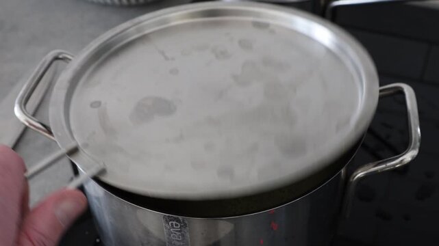 Stockholm, Sweden A whole head of cauliflower boils in a pot of vegetable bouillon on a stove. 