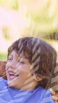 Vertical video: Boy dropping hand laughing to offframe call for health striped leaf overlay passing