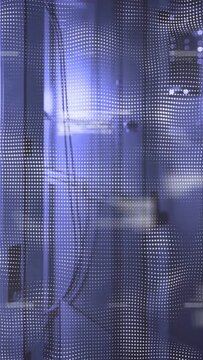 Vertical video: Perforated LED mesh shifting highlights after bright flare, revealing window behind