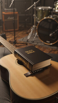 A Holy Bible rests on an acoustic guitar in a music studio. Vertical photo representing the concept of Christian faith, worship, and gospel music