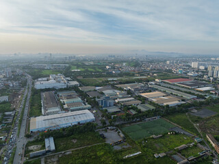 Fototapeta premium Aerial daytime view of an industrial cluster in Long Bien district, Hanoi, showing factories, warehouses, roads, and surrounding urban and green areas.