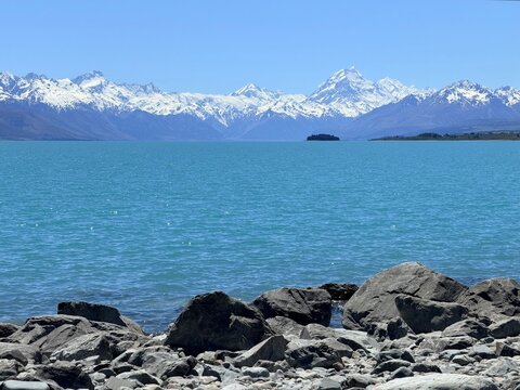 Mount Cook Aoraki Snow Peak Over Turquoise Lake Pukaki with Rocky Shoreline in New Zealand