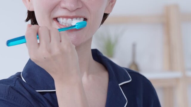 パジャマ姿で歯を磨く女性