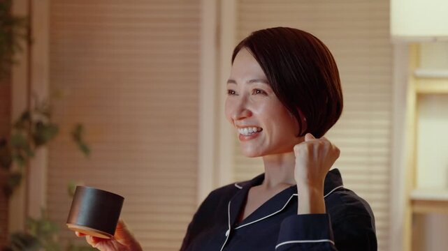 夜にテレビを観る女性