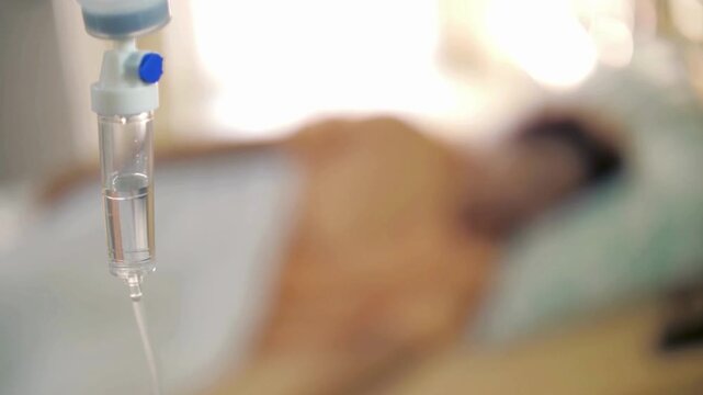 Close up of IV drip in hospital, Patient, blurred background Man is receiving intravenous fluid Elderly man caucasian patient on hospital bed top