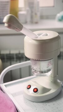 Vertical video. Ozone facial steamer. Clean procedure. Modern electronic device for skin treatment in beauty professional salon.