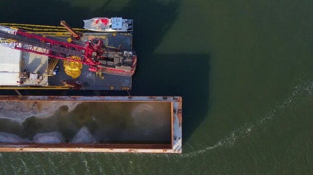 Dredging barge moving sediment in Sting Ray Cove on Anclote River, Florida, USA