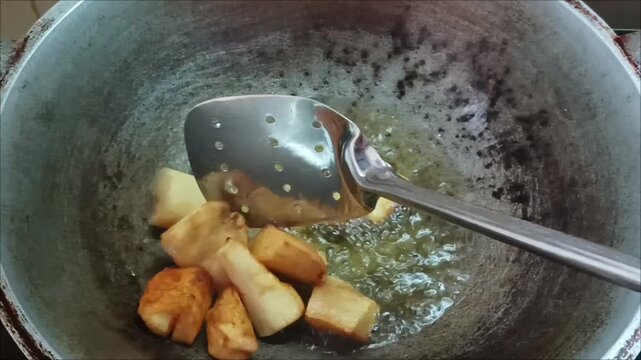 Fry fresh cassava pieces in a pan