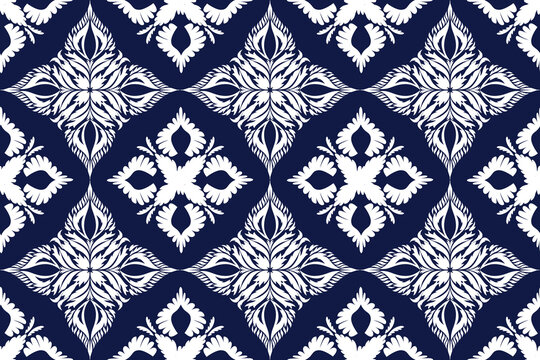 Classic Thai-inspired seamless pattern in deep navy blue and white. Intricate symmetrical floral and foliage motifs with traditional Thai Kanok (flame-like) and lotus elements arranged in a repeating 