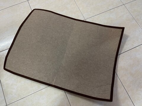 A non-rollable thick jigsaw puzzle felt board showing permanent creases and damage caused by forced folding during shipping.