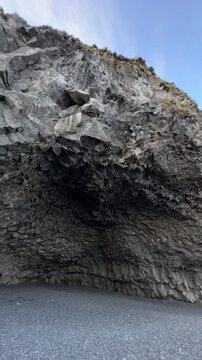 View from outside looking into the basalt column cave of Halsanefshellir on Reynisfjara black sand beach, South Iceland