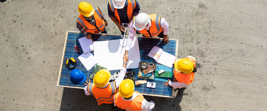 Ethnic diversity worker people, Success teamwork. Group of professional engineering people wearing hardhat safety helmet meeting with solar photovoltaic panels discussion in new project