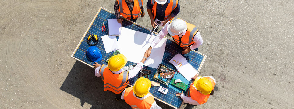 Ethnic diversity worker people, Success teamwork. Group of professional engineering people wearing hardhat safety helmet meeting with solar photovoltaic panels discussion in new project