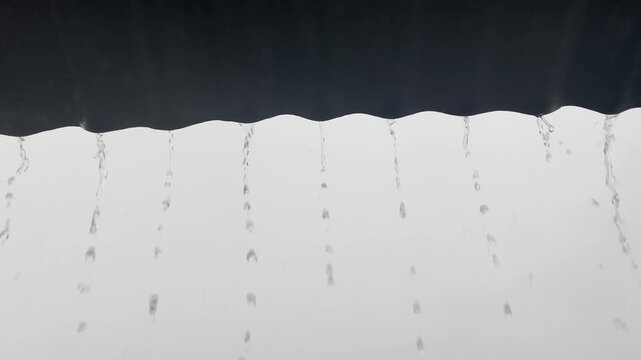 Heavy Rain Falling from Corrugated Metal Roof Edge