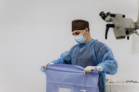 Surgeon preparing sterile sheet for surgery