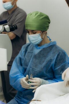 Surgeon performing eye operation with specialized equipment