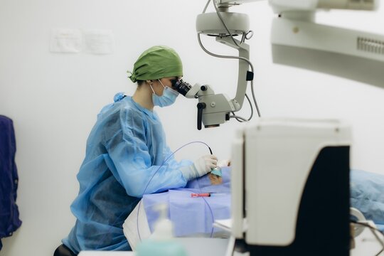 Ophthalmologist performing eye surgery using microscope in clinic