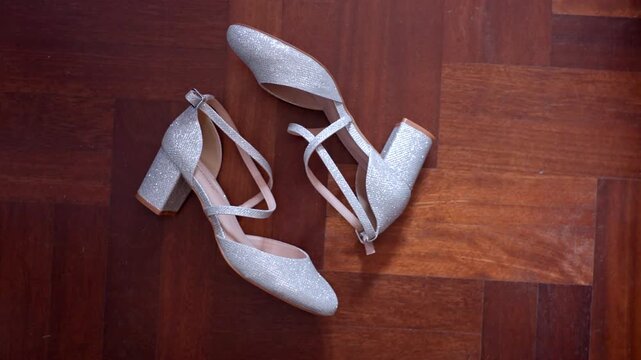 Sparkly silver high heels on wood floor, elegant fashion vibe