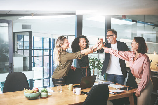 Group, celebration and high five in boardroom, collaboration and happy for assignment goals success. Business, people and gesture for project achievement, teamwork and colleagues with smile for win