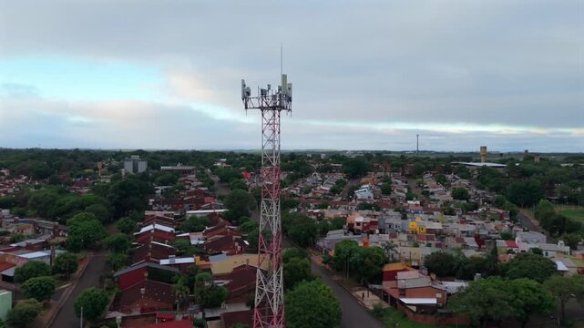 Telecommunications tower in Posadas municipality Misiones province Northeast region Argentina along Avenida Tambor de Tacuar&iacute; above residential grid, drone orbit push in