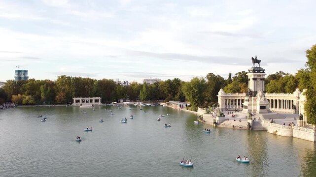 Aerial view of tourists on boats enjoying an autumn day on a great pond in front of monument to Alfonso XII at the Retiro Park (Parque del Buen Retiro) in Madrid, Spain.